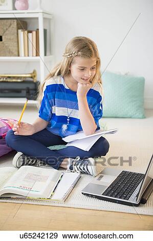 Stock Photo - Girl (8-9) doing homework. Fotosearch