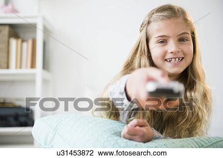 Girl (8-9) holding remote control View Large Photo Image Stock Image - Girl (8-9) holding remote control. Fotosearch