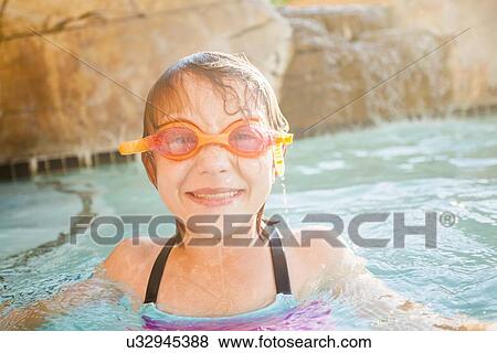 Girl (8-9) playing in swimming pool View Large Photo Image Stock Photo - Girl (8-9) playing in swimming pool. Fotosearch