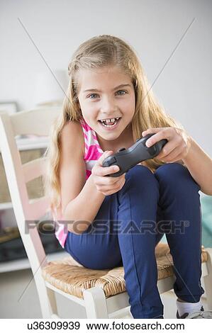 Stock Photo - Girl (8-9) playing video game . Fotosearch