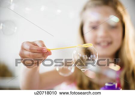 Girl (8-9) playing with bubbles View Large Photo Image Stock Image - Girl (8-9) playing with bubbles. Fotosearch