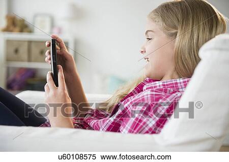 Girl (8-9) reading e-reader View Large Photo Image Stock Photography - Girl (8-9) reading e-reader. Fotosearch
