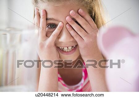 Girl (8-9) smiling and covering eyes View Large Photo Image Picture - Girl (8-9) smiling and covering eyes. Fotosearch