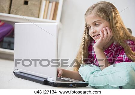 Picture - Girl (8-9) using laptop. Fotosearch