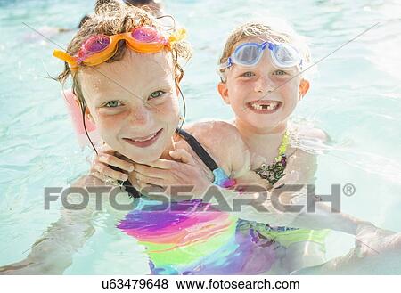 Stock Photo - Girlfriends (4-5, 8-9) playing in swimming pool. Fotosearch