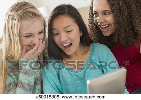 Girls (12-13, 14-15, 16-17) playing with tablet View Large Photo Image Stock Photography - Girls (12-13, 14-15, 16-17) playing with tablet. Fotosearch