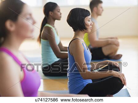 Group of young people meditating View Large Photo Image Stock Photograph - Group of young people meditating . Fotosearch