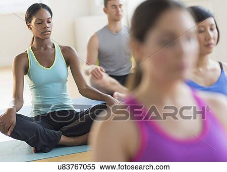 Stock Photography - Group of young people meditating . Fotosearch