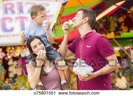 Happy family with son (4-5) in amusement park eating cotton candy View Large Photo Image Stock Image - Happy family with son (4-5) in amusement park eating cotton candy. Fotosearch