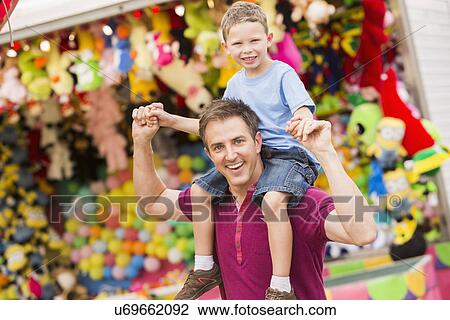 Happy father with son (4-5) in amusement park View Large Photo Image Stock Image - Happy father with son (4-5) in amusement park. Fotosearch