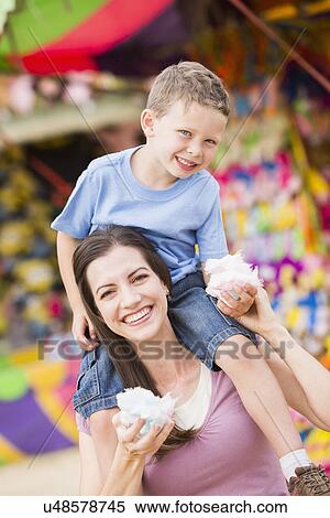 Happy mother with son (4-5) in amusement park eating cotton candy View Large Photo Image Stock Photography - Happy mother with son (4-5) in amusement park eating cotton candy. Fotosearch