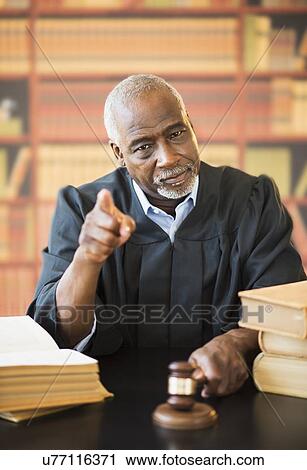 Judge holding gavel in courtroom and pointing View Large Photo Image Stock Image - Judge holding gavel in courtroom and pointing. Fotosearch