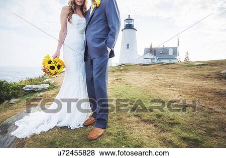 Low section of married couple, lighthouse in background View Large Photo Image Stock Photo - Low section of married couple, lighthouse in background. Fotosearch