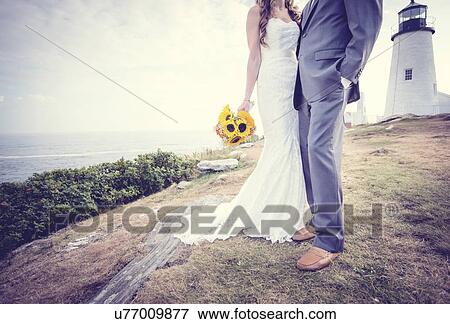 Low section of married couple, lighthouse in background View Large Photo Image Stock Photo - Low section of married couple, lighthouse in background. Fotosearch