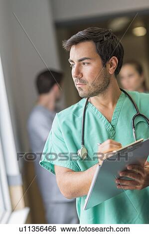 Male doctor in hospital hallway View Large Photo Image Stock Photograph - Male doctor in hospital hallway. Fotosearch