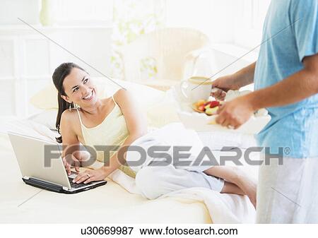Man serving breakfast to woman in bed View Large Photo Image Stock Photo - Man serving breakfast to woman in bed. Fotosearch