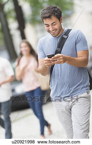 Stock Photo - Man texting in street. Fotosearch