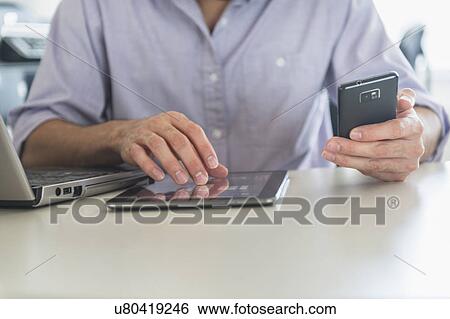 Stock Photograph - Man using technology in office. Fotosearch