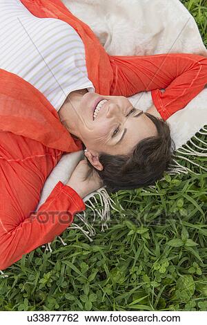 Mature woman lying on grass View Large Photo Image Stock Image - Mature woman lying on grass. Fotosearch