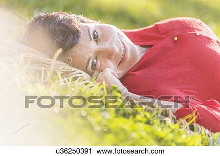 Mature woman lying on grass View Large Photo Image Stock Image - Mature woman lying on grass. Fotosearch