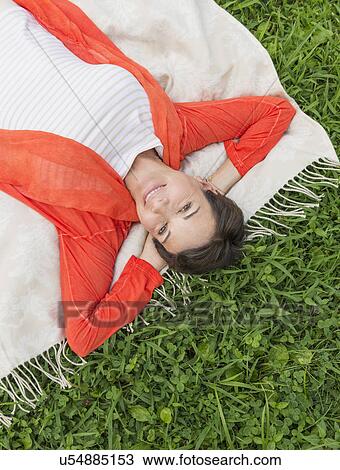 Stock Image - Mature woman lying on grass. Fotosearch