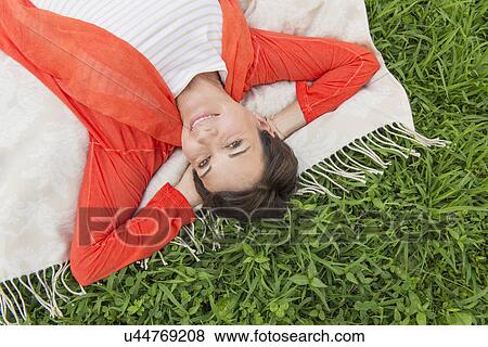 Mature woman lying on grass View Large Photo Image Stock Photo - Mature woman lying on grass. Fotosearch