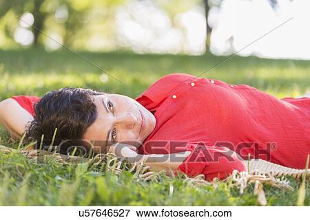 Mature woman lying on grass View Large Photo Image Stock Photo - Mature woman lying on grass. Fotosearch