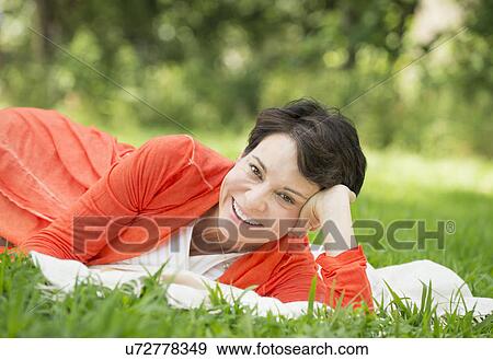 Mature woman lying on grass View Large Photo Image Stock Photo - Mature woman lying on grass. Fotosearch