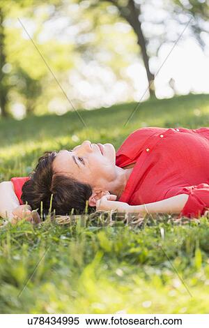 Mature woman lying on grass View Large Photo Image Stock Photography - Mature woman lying on grass. Fotosearch