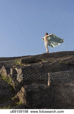 Mature woman standing on cliff with arms raised View Large Photo Image Stock Photo - Mature woman standing on cliff with arms raised. Fotosearch