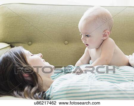 Mother and baby boy (6-11 months) lying on sofa View Large Photo Image Stock Image - Mother and baby boy (6-11 months) lying on sofa. Fotosearch