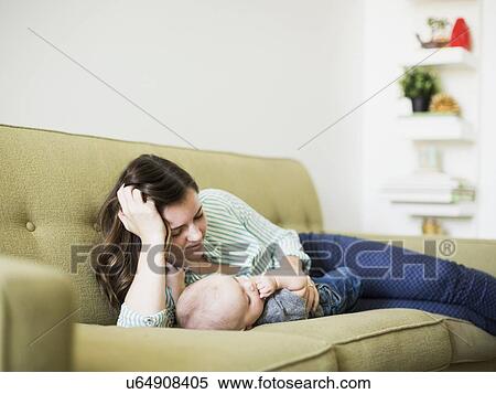 Mother and baby boy (6-11 months) lying on sofa View Large Photo Image Stock Photography - Mother and baby boy (6-11 months) lying on sofa. Fotosearch