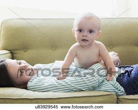 Mother and baby boy (6-11 months) lying on sofa View Large Photo Image Stock Photography - Mother and baby boy (6-11 months) lying on sofa. Fotosearch