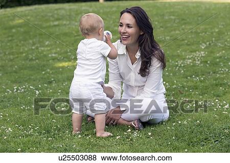 Stock Photo - Mother and daughter (12-17 months) playing in park. Fotosearch