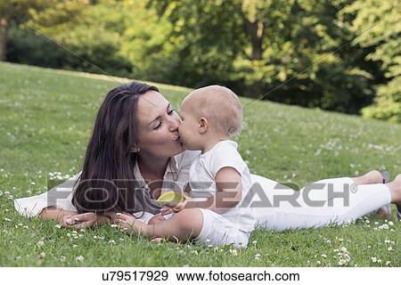 Mother and daughter (12-17 months) playing in park View Large Photo Image Stock Photo - Mother and daughter (12-17 months) playing in park. Fotosearch