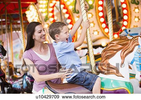 Mother and son (4-5) on carousel in amusement park View Large Photo Image Stock Photo - Mother and son (4-5) on carousel in amusement park. Fotosearch