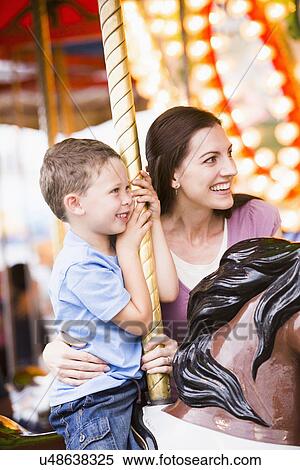 Mother and son (4-5) on carousel in amusement park View Large Photo Image Stock Photography - Mother and son (4-5) on carousel in amusement park. Fotosearch