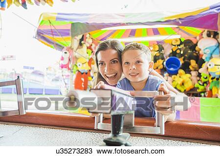 Mother and son (4-5) playing with water gun in amusement park View Large Photo Image Stock Image - Mother and son (4-5) playing with water gun in amusement park. Fotosearch