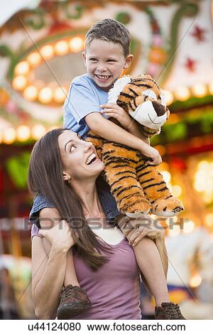 Mother giving her son (4-5) piggyback ride in amusement park View Large Photo Image Stock Image - Mother giving her son (4-5) piggyback ride in amusement park. Fotosearch