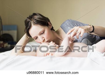 Stock Image - Mother kissing baby boy (2-5 months). Fotosearch
