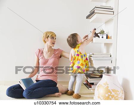 Picture - Mother playing with baby daughter (12-17 months). Fotosearch