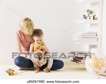 Stock Image - Mother playing with baby daughter (12-17 months). Fotosearch
