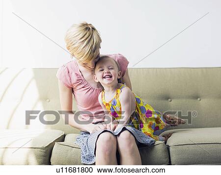 Mother with daughter (12-17 months) sitting on sofa View Large Photo Image Stock Image - Mother with daughter (12-17 months) sitting on sofa. Fotosearch