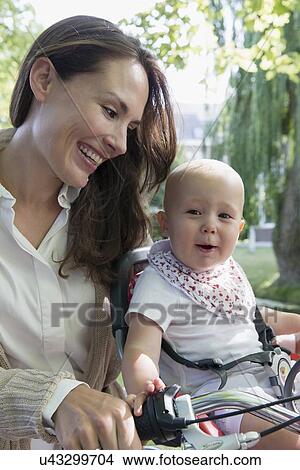 Mother with her baby daughter (12-17 months) on bicycle View Large Photo Image Picture - Mother with her baby daughter (12-17 months) on bicycle. Fotosearch