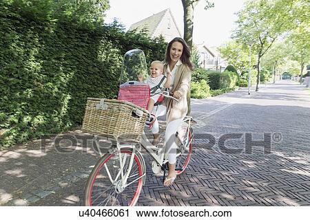 Mother with her baby daughter (12-17 months) on bicycle View Large Photo Image Stock Image - Mother with her baby daughter (12-17 months) on bicycle. Fotosearch