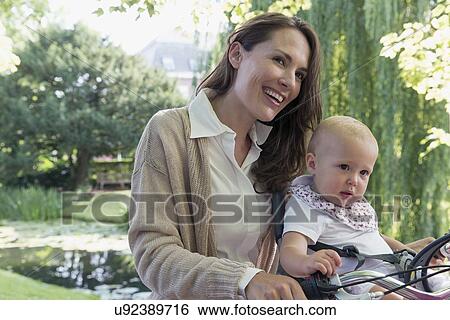 Mother with her baby daughter (12-17 months) on bicycle View Large Photo Image Stock Photograph - Mother with her baby daughter (12-17 months) on bicycle. Fotosearch