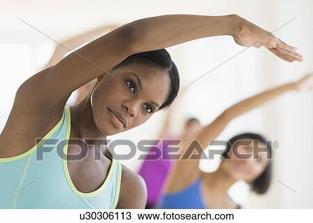 Stock Image - People stretching in gym. Fotosearch