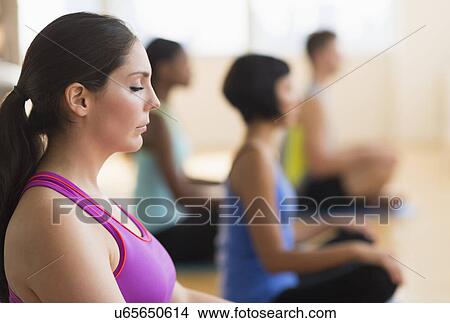 Picture - People training yoga in gym. Fotosearch