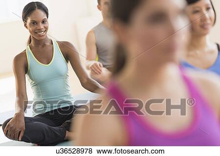 Stock Photo - People training yoga in gym. Fotosearch