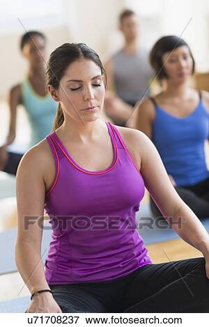 Stock Photo - People training yoga in gym. Fotosearch